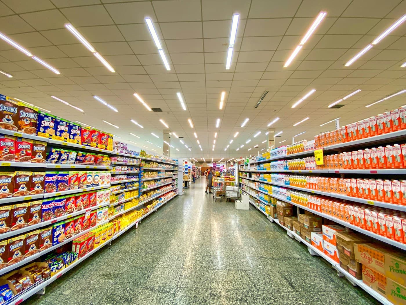 An organized supermarket aisle lined with packaged grocery essentials